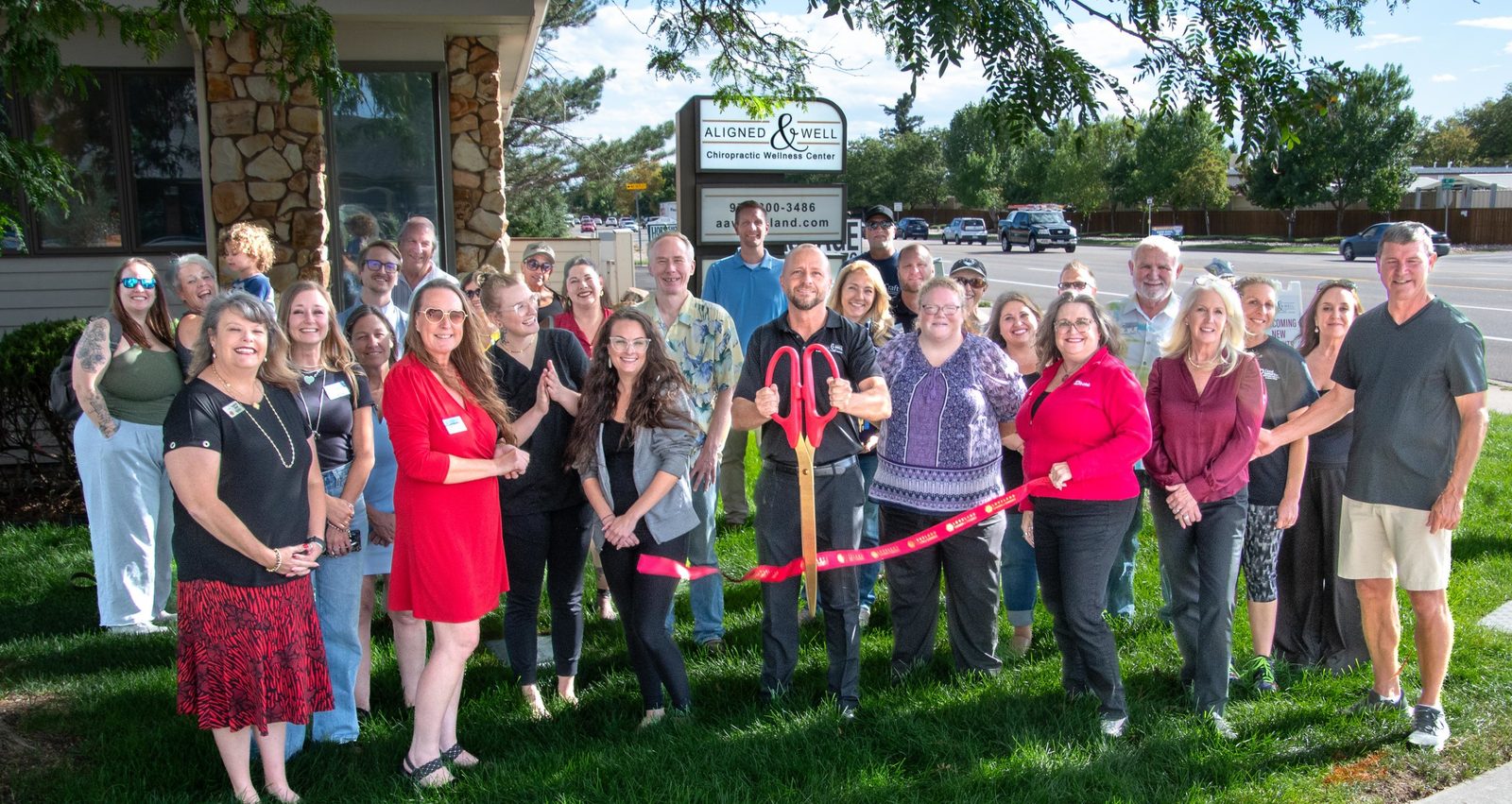 Loveland Chamber of Commerce ribbon cutting at Aligned and Well Chiropractic with patients, Chamber members and staff